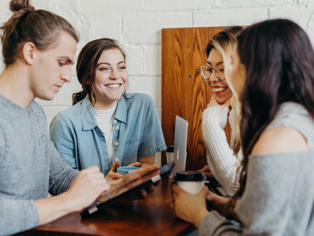 Coach en sesión con un grupo de clientes alrededor de una mesa.