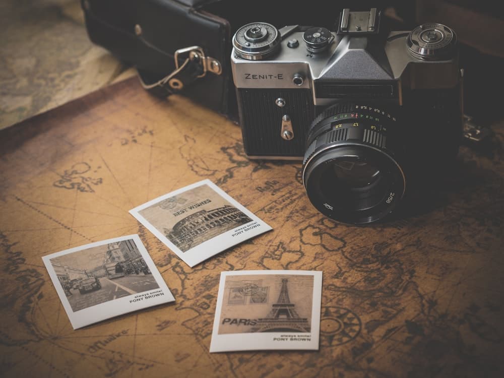 Cámara fotográfica junto a copias impresas de fotografías.